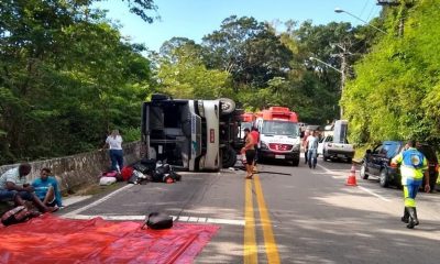 ônibus tombado em rodovia, ambulâncias e agentes prestando socorro aos passageiros