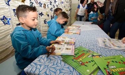 Meninos assinando livro de histórias