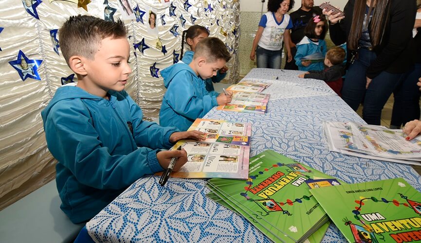 Meninos assinando livro de histórias