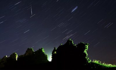 Foto tirada com longa exposição mostra um meteoro Perseid cruzando o céu na vertical e o rastro das estrelas acima das ruínas de um castelo medieval na vila de Kreva, a cerca de 100 km a noroeste de Minsk, na Bielorrússia