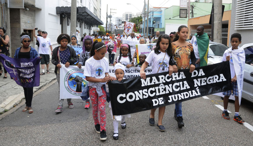 Jovens em marcha pela rua com faixa "marcha da consciência negra de jundiaí"