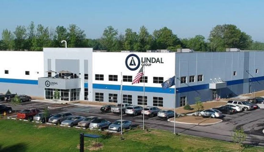 Prédio empresarial do Grupo Lindal, com estacionamento de veículos em volta