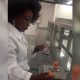 Foto de perfil mostra estudante com jaleco em laboratório, fazendo testes no produto