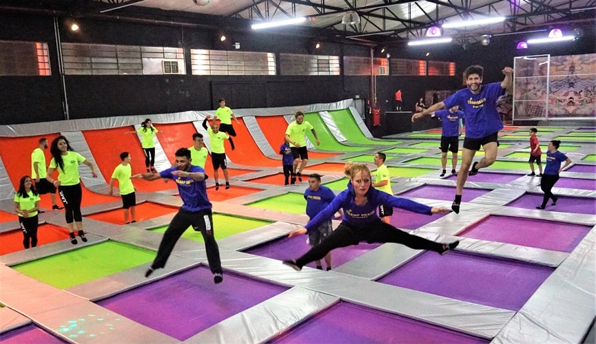 Pessoas pulando em uma cama elástica gigante do parque JumPark