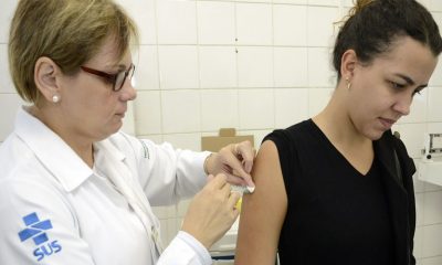 Enfermeira vacinando mulher adulta