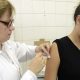 Enfermeira vacinando mulher adulta