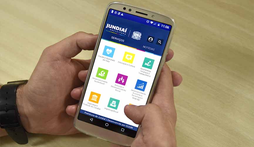 mão segura celular e na tela está aberto o app jundiaí