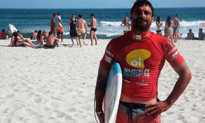 Foto de Leo Neves com prancha na mão ainda na areia