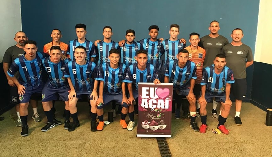 Jogadores do time de futsal segurando placa com os dizeres: "Eu amo açaí"