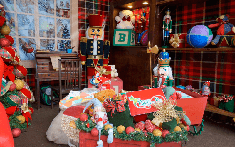 Cenário de Natal tem casa do Papai Noel, com escritório natalino