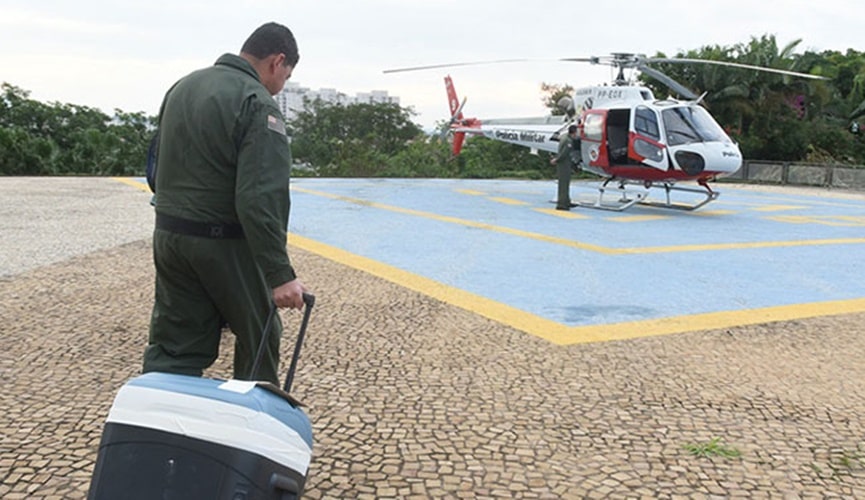 Equipe médica levando mala de transporte de órgãos ao helicóptero