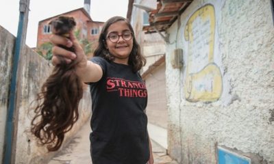 Menina de óculos segurando mecha de cabelo