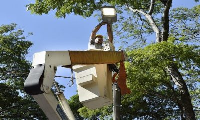 Eletricista instalando luminária de LED em poste