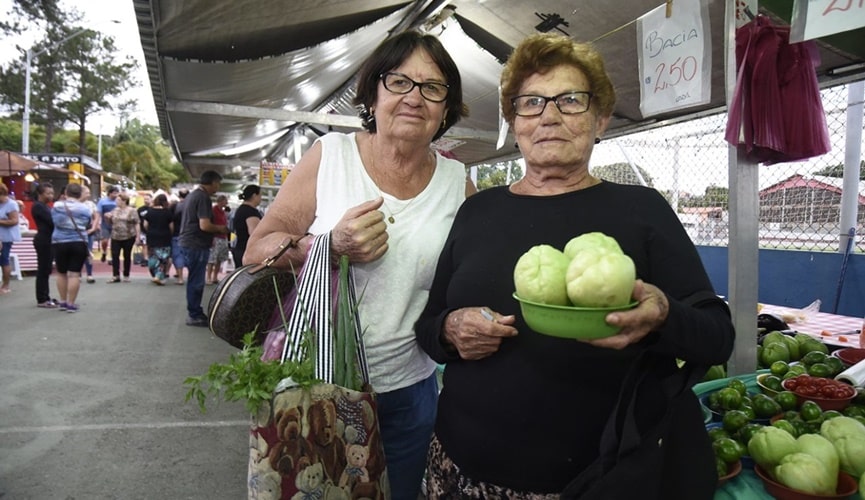 Senhoras segurando cestinhas da feira