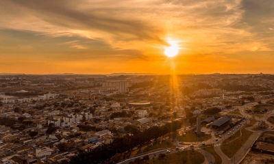 foto aérea de jundiaí com cidade abaixo e sol brilhando no céu com céu alaranjado