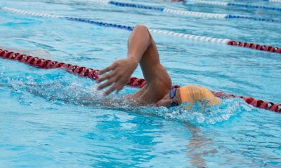 Rapaz nadando em piscina olímpica