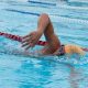 Rapaz nadando em piscina olímpica