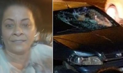 Selfie de mulher de meia idade parda, à direita; carro preto destruído, à esquerda