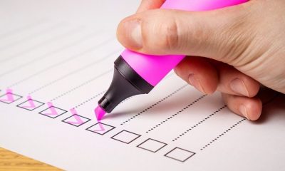 Pessoa marcando lista com uma caneta marca-texto rosa
