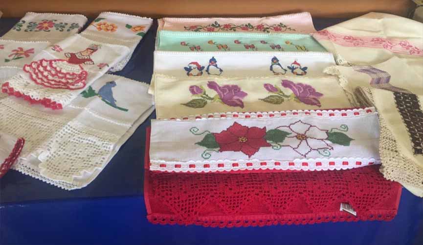 toalhas artesanais com bordados expostas em mesa