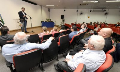 público em auditório acompanhando fala do prefeito de jundiaí no palco à frente