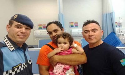 guarda municipal ao lado de familiares de bebê que foi salva pelo guarda após desmaio