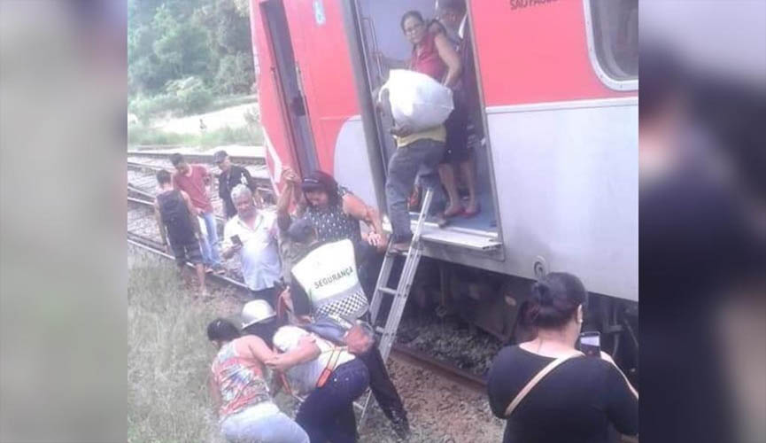 pessoas descendo de trem no meio do trilho