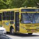 Ônibus de transporte público amarelo com letreiro lateral escrito Jundiaí transita em avenida da cidade