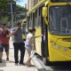 ônibus amarelo de jundiaí parado em avenida enquanto pessoas que estão na calçada paradas no ponto de ônibus sobem para dentro dele