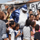 Papai Noel vestido de azul abraçando crianças
