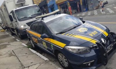 Caminhão estacionado atrás de viatura da Polícia Rodoviária