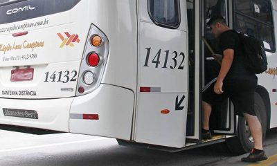 Foto de passageiro entrando em ônibus branco da Rápido Luxo