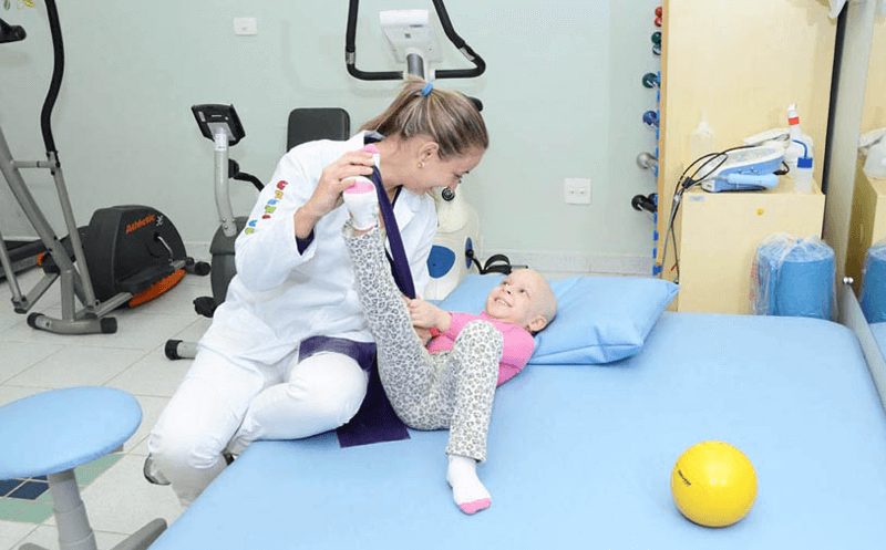Profissional realiza fisioterapia com criança assistida pelo Grendacc