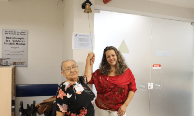Dona Irene e a filha, Valéria, tocando sino símbolo do fim do tratamento.