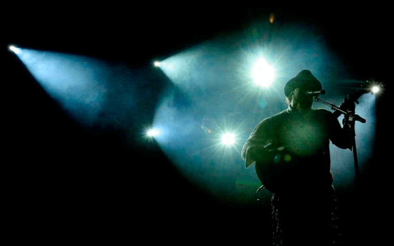 Cantor se apresenta em palco com cores frias na iluminação