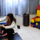 Profissional em sala de recursos auxilia criança com deficiência visual