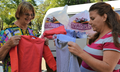Mulheres dobram agasalhos para colocar em sacolas do Fundo Social de Solidariedade
