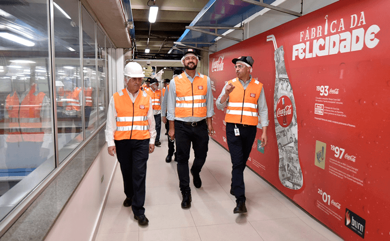 Luiz e diretores da Coca-Cola andando pela empresa