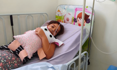 Criança abraçada com naninha em casa hospitalar