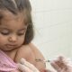 Criança tomando vacina de Sarampo