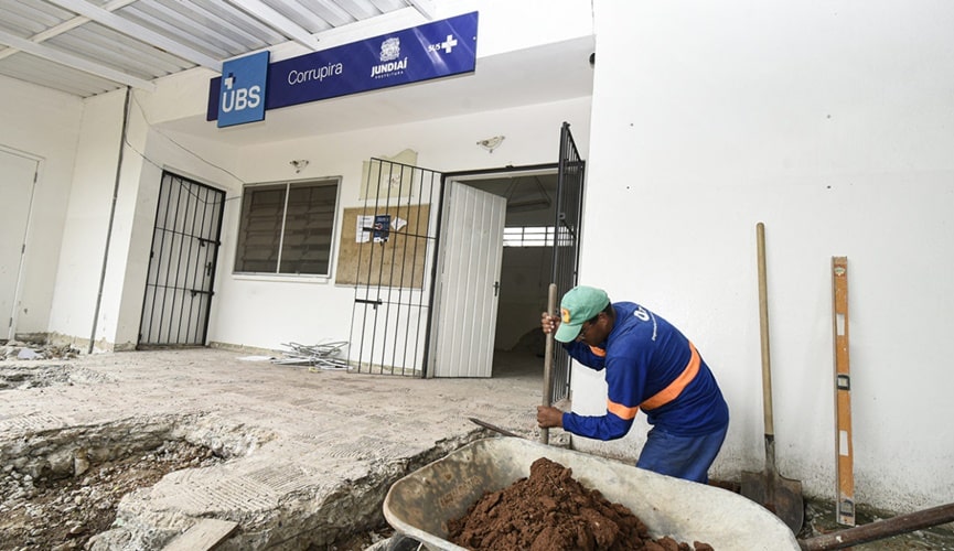 Pedreiro enchendo carrinho de mão com terra em UBS de Jundiaí