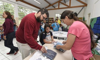 Foto de pais retirando uniforme escolar nas escolas