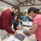 Foto de pais retirando uniforme escolar nas escolas