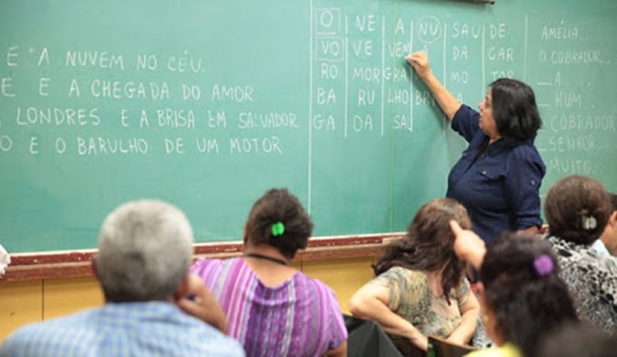 Foto de professora dando aula para pessoas da terceira idade