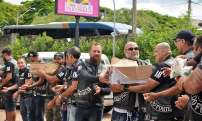 Integrantes de motoclube descarregando alimentos