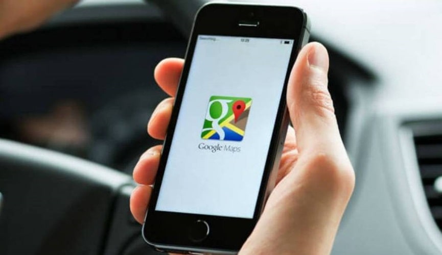 Foto de mão segurando celular com tela do aplicativo google maps aberta