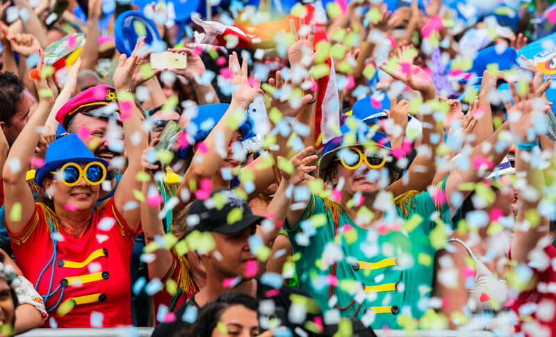 Foliões com adereços de Carnaval jogam serpentina e confetes