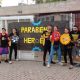 Equipe de estudantes em frente a cartaz de parabéns