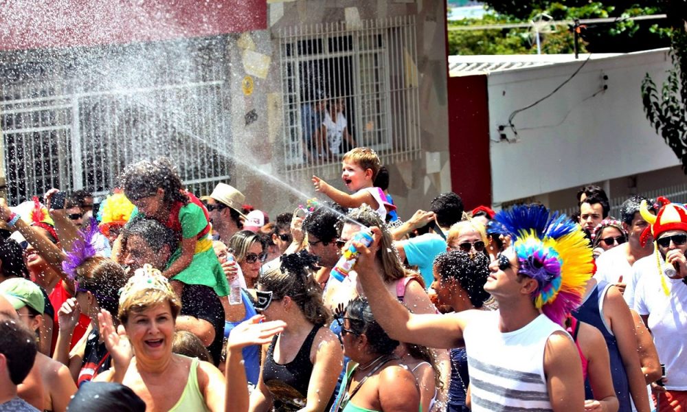 pessoas se divertindo em uma rua durante o bloco de carnaval