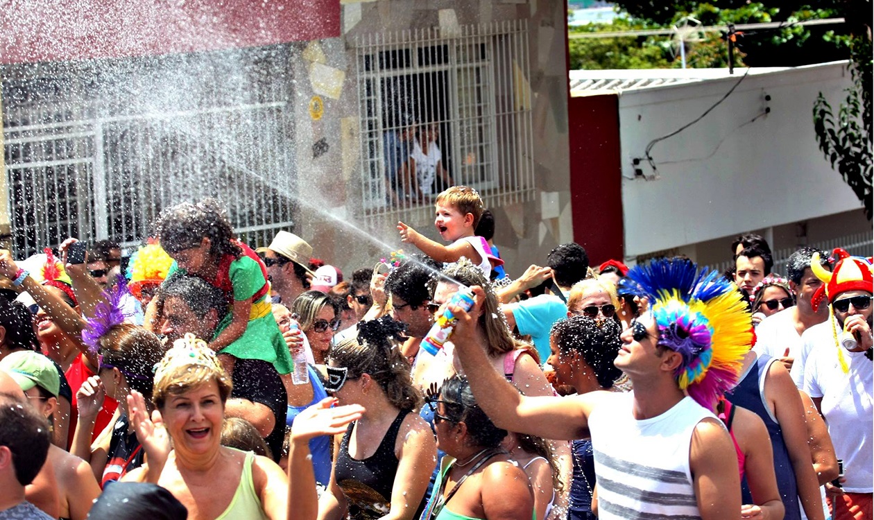 pessoas se divertindo em uma rua durante o bloco de carnaval